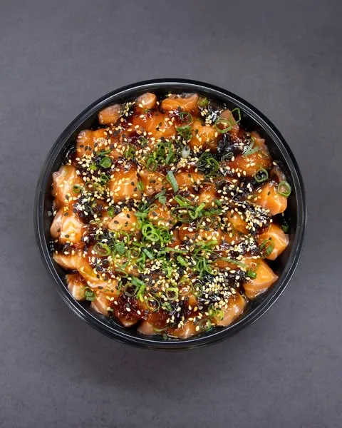 Poke com cubos de salmão e cobertura de molho e gergelim visto de cima