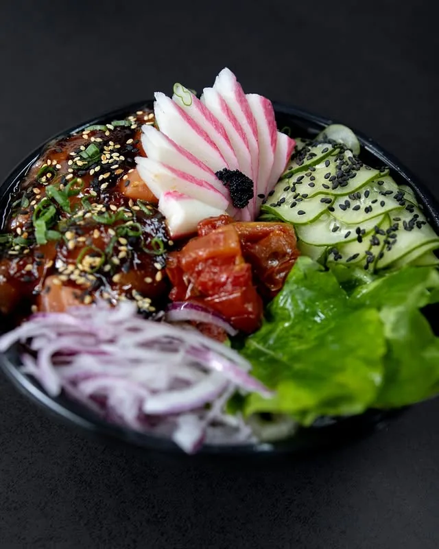 Tigela de poke com cubos de salmão, pepino e cebola roxa