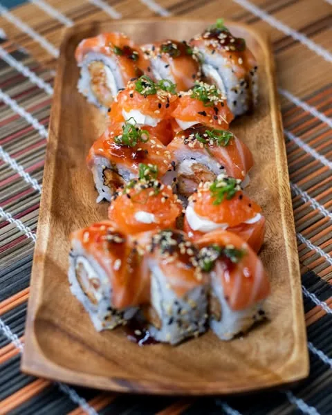 Uramakis especiais com cobertura de salmão e molhos do O Quinto Sabor